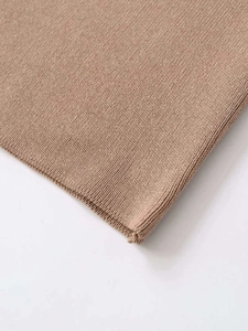 Détail du tissu en maille fine marron clair montrant une texture lisse et des finitions