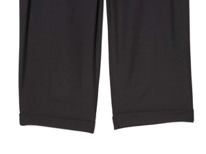 Détail d'un pantalon noir taille haute avec ourlet revers fixe et tissu en sergé fini