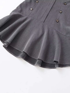 Detail of dark grey fishtail skirt featuring pleated hem and brown buttons