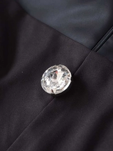 Gros plan détaillé d'un gros bouton en cristal facetté sur un vêtement en tissu noir
