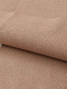 Détail macro du tissu en maille côtelée camel montrant des rayures verticales de qualité