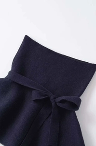 Detail of navy blue high-waist knit fabric featuring a decorative matching waist tie bow