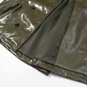 Detail of dark green glossy leather jacket with button closure and smooth inner lining