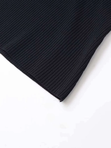 Close-up detail of high-quality black ribbed knit fabric showing neat edge stitching