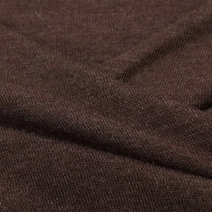 Gros plan sur un tissu en maille marron foncé doux avec une texture fine et des plis