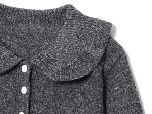 Macro shot of grey knit cardigan with Peter Pan collar and white buttons detail