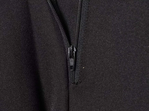 Détail macro de la fermeture à glissière noire de qualité sur le pantalon taille haute élégant
