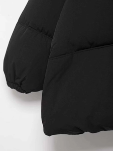 Detail of windproof elastic ribbed cuff and horizontal quilting on black padded puffer jacket