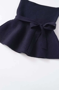 Detailed macro view of dark blue knitted fabric texture with stylish bow tie waist design