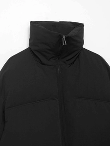 Close-up of black stand collar puffer jacket with matte fabric and silver metal zipper detail