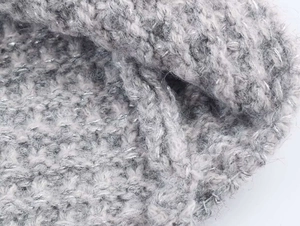 Gros plan détaillé d'un tissu en maille grise avec de discrets fils métalliques argentés