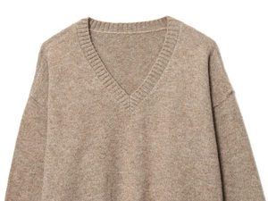 Détail de la maille texturée et de l'encolure en V côtelée sur un pull marron