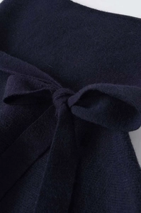 Detail of navy blue knitted fabric featuring a decorative soft tie-knot texture