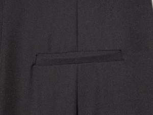 Gros plan détaillé sur la couture de poche passepoilée d'un pantalon en sergé