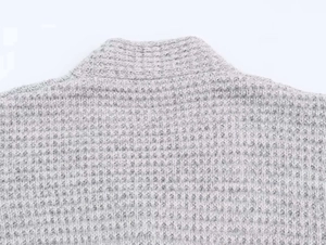 Gros plan sur la maille gaufrée grise et l'encolure côtelée de ce gilet long pour femme