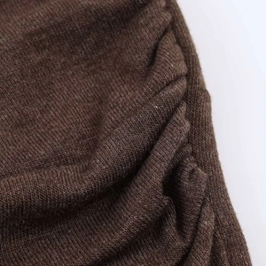 Gros plan sur un tissu en maille marron foncé avec plis et texture fine