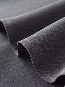 Detailed close-up of charcoal gray fabric texture and stitching on sleeveless fishtail dress