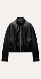 Detail of faux leather jacket featuring stand collar with gold buttons and zip closure