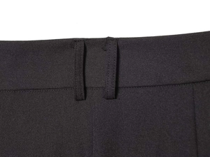 Détails de la taille haute asymétrique du pantalon noir avec passants et finitions précises