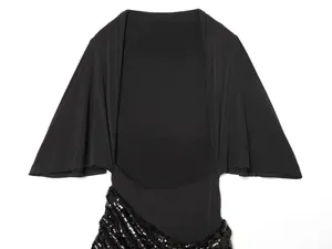 Dettaglio di abito nero con maniche a mantella e decorazioni di paillettes diagonali