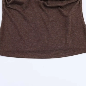 Gros plan détaillé du tissu en maille marron montrant la texture douce et les coutures