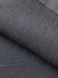 Detailed close-up of dark grey double-breasted fishtail dress twill fabric texture