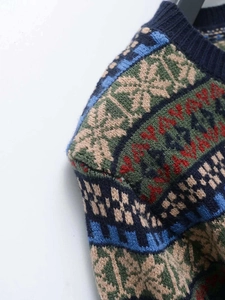 Detailed close-up of retro Fair Isle jacquard knit sweater with snowflake patterns