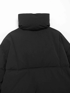 Close-up back view of black quilted puffer jacket featuring a stand collar and matte finish