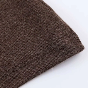 Vue macro de l'ourlet en tricot marron montrant les coutures et la texture du tissu