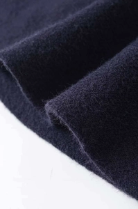 Macro shot of plush navy blue wool fabric showing soft fuzzy texture and material detail