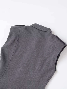 Detail of grey sleeveless vest showing the lapel collar and shoulder epaulettes design