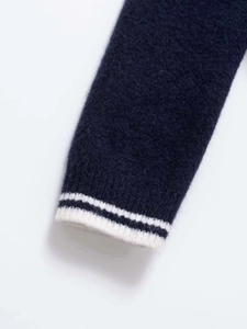 Close-up of navy knit sleeve with white stripes showing soft mohair texture