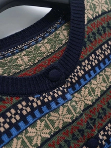 Detail of vintage Fair Isle knit cardigan neck with jacquard pattern and button closure