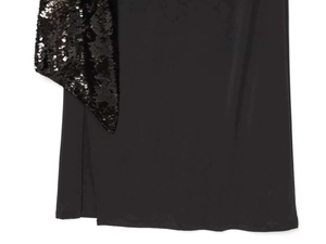 Dettaglio del ricamo di paillettes nere e delle cuciture in tessuto liscio sul vestito