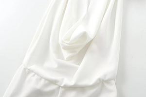 Detail of pure white deep V-neckline with elegant pleated drape fabric textures