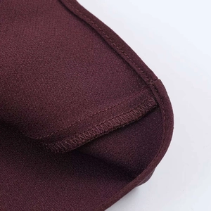 Détail d'une robe en satin bordeaux montrant des coutures surjetées et une finition soignée