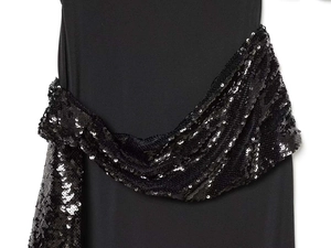 Dettaglio dell'abito nero senza maniche con paillettes in vita e tessuto opaco