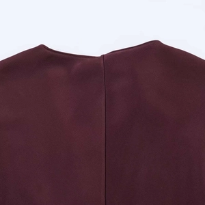 Détail d'une robe en satin bordeaux montrant la couture du dos et la texture du tissu