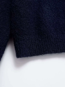 Detailed macro view of navy knit sweater showing ribbed hem and side slit details