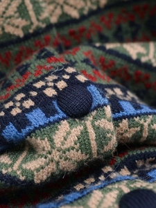 Close-up of vintage geometric jacquard knit fabric with a matching fabric-covered button
