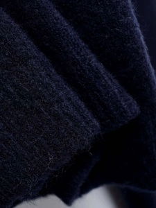 Close-up of navy blue knit fabric showing soft mohair wool texture and thick weave fibers