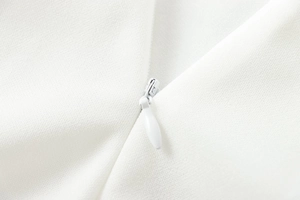 Detail of white crepe fabric texture and seamless invisible zipper on the halter jumpsuit