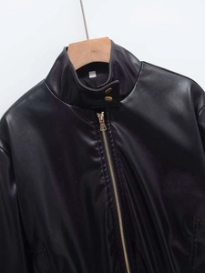 Detail of faux leather jacket with stand collar and gold snap buttons and zipper