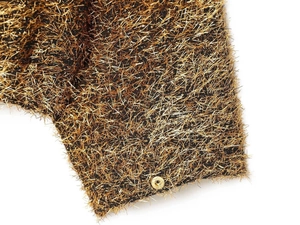 Macro detail of metallic gold threads and a snap button on a black bomber jacket