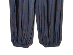 Detailed close-up of dark blue plaid pattern and elastic cuffs on loose lantern pants