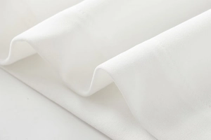 Detailed macro view showing the soft white crepe fabric texture and elegant draping