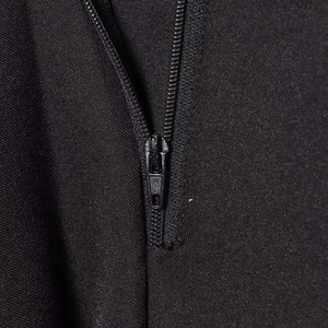 Détail du pantalon en tissu noir avec fermeture éclair métallique de haute qualité et texture