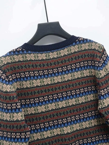 Detailed view of the ribbed crew neck and colorful geometric jacquard knit pattern