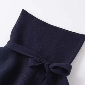 Navy blue high waist top featuring a stylish ruffle hem and a large decorative bow tie