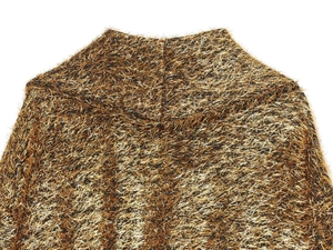 Macro detail of golden metallic fiber knit and soft long-plush texture on a high-neck jacket